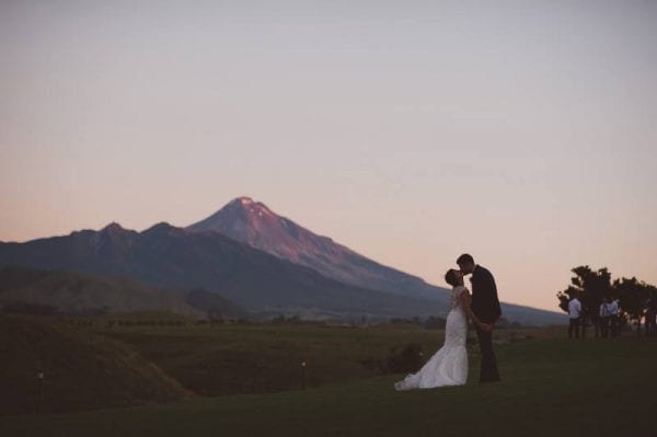 bride and groom kissing under the mountain
